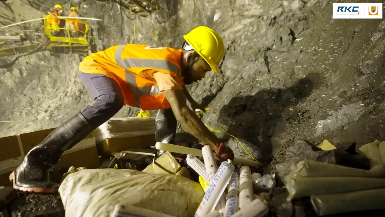 A crew charging blast holes at a tunnel face