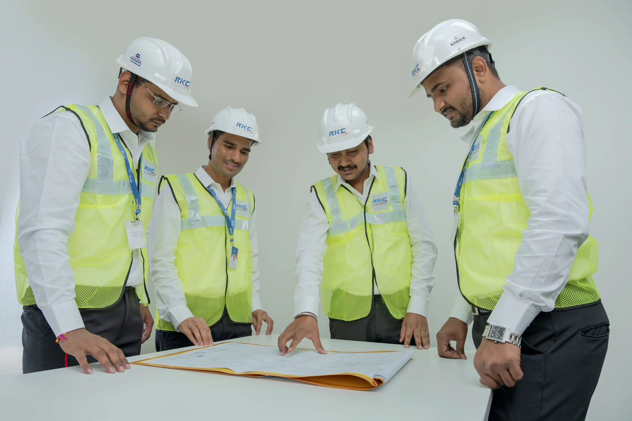 Four RKC engineers in hard hats going over a drawing together
