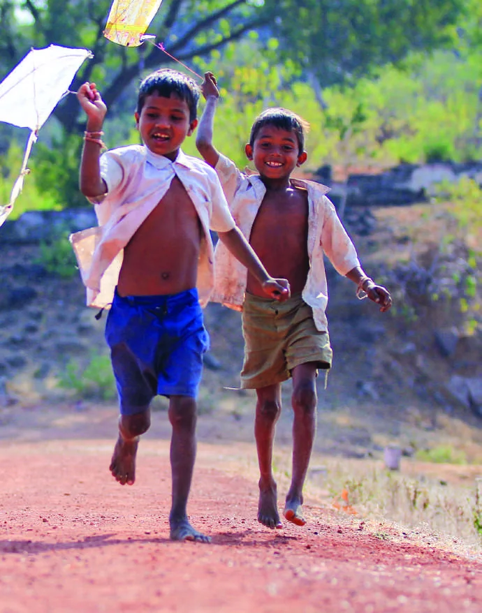 Two children running along a village road