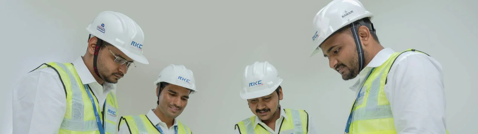 Four RKC engineers in hard hats going over a drawing together