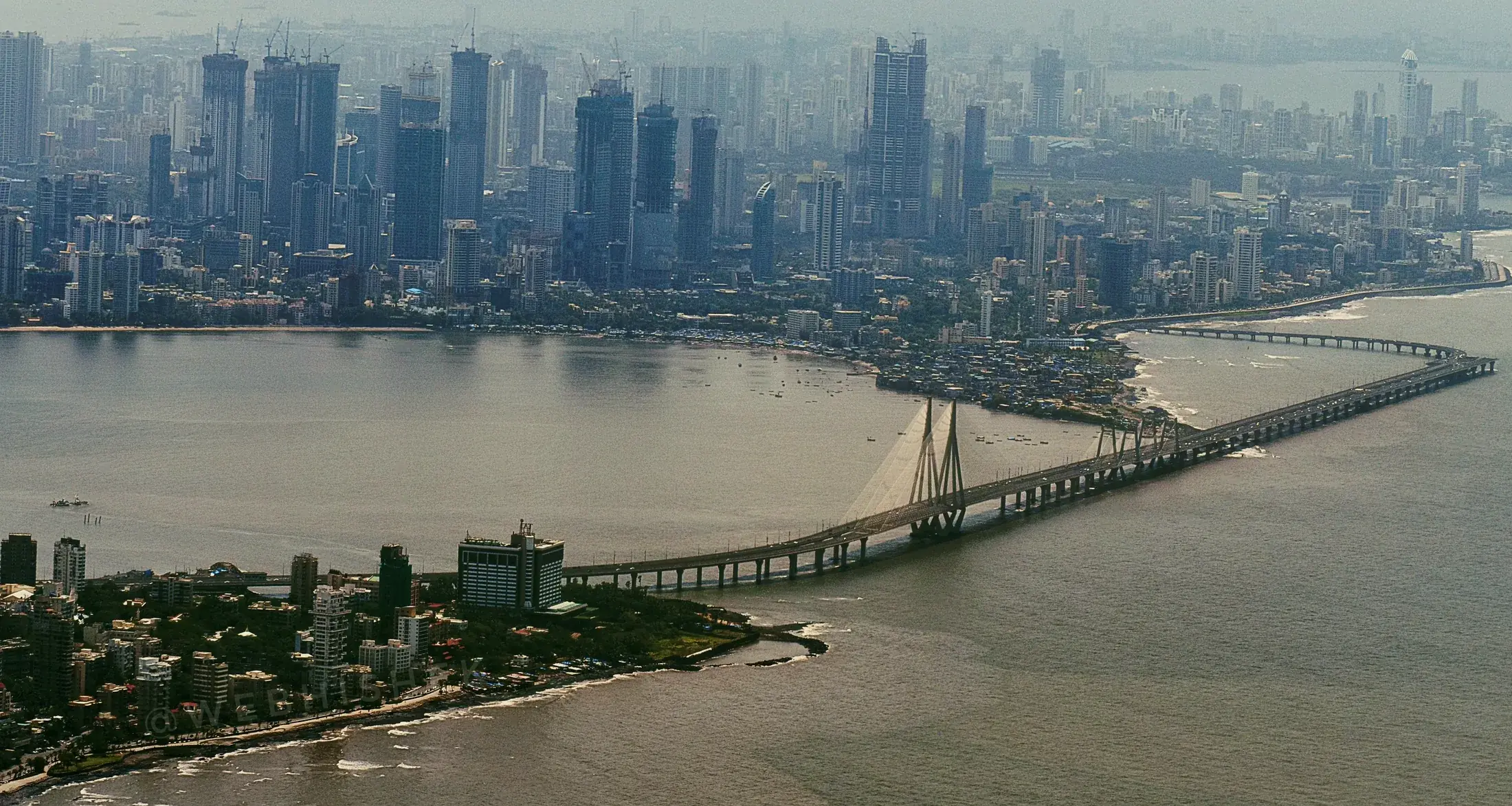 A sea link bridge against a city skyline